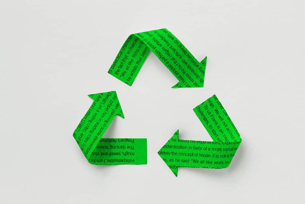 Grön återvinningssymbol gjord av tidningspapper